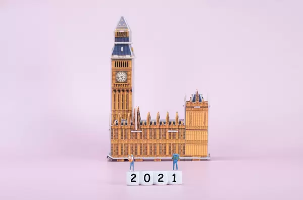 Two travelers standing on blocks with 2021 text in front of Big Ben