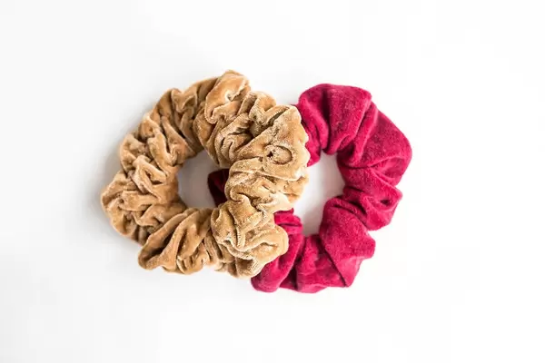 Two velvet scrunchies on white background top view