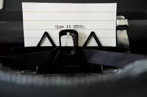 Type it HERE: auf einem Papier in einer Vintage Schreibmaschine aus dem Blickwinkel des Schreibers