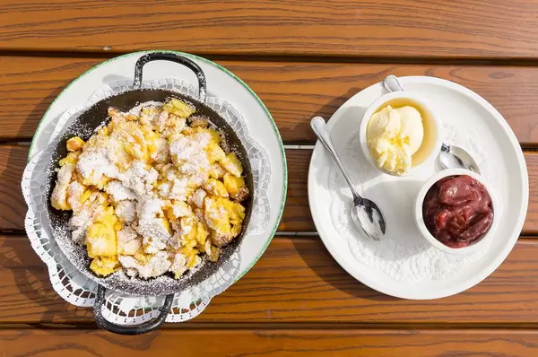 Typical Austrian food: top view of Kaiserschmarrn served with stewed plums and vanilla ice cream