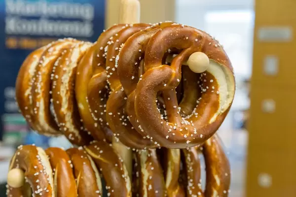 Typicall German pretzel pastry on a wooden stand at breakfast buffet at OMWest Barcamp by AXA in Cologne