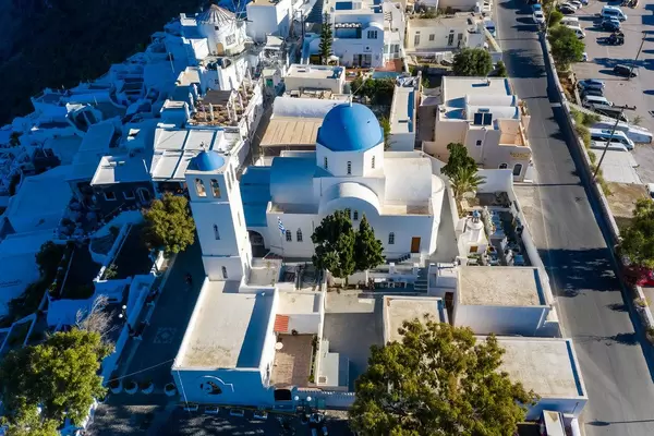 Typische griechische Kirche mit blauer Kuppel und Glockenturm auf Santorin. Luftaufnahme