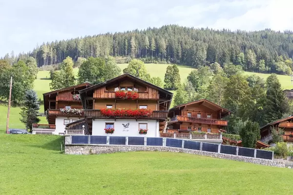 Typische Holzhäuser im alpinen Stil in Tirol mit Satteldach und mit Blumen geschmückten Balkonen