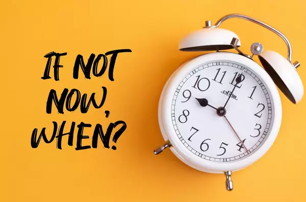 Überwinden Prokrastination: Wecker mit dem Text ‘If not now, when?’ vor gelbem Hintergrund