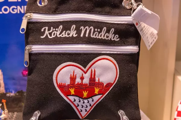 Umhängetasche mit Schriftzug "Kölsche Mädche" und einem Herz mit Kölnwappen sowie Stadtprofil