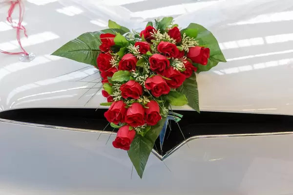 Umweltfreundliche Hochzeit: Rosenstrauß dekoriert die Motorhaube am "Traumhochzeitsauto" Tesla Model X P90DL, in der Nahaufnahme