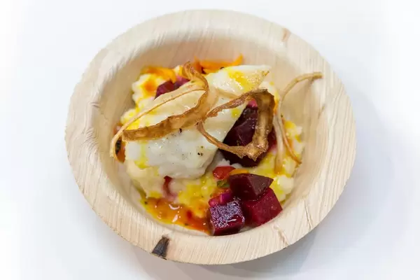 Umweltfreundlicher Einwegteller mit Fisch, Gemüse, roter Bete und Zwiebeln auf weißem Hintergrund