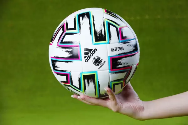 Uniforia official EURO 2020 ball in hands of a woman, green background