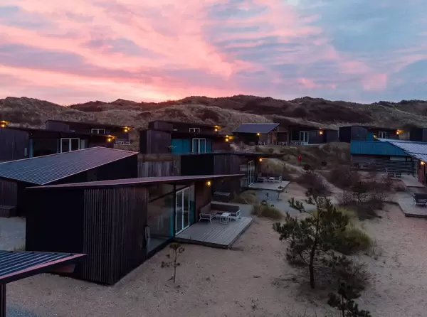 Untergehende Sonne spiegelt sich in den Dächern von Ferienhäusern in den Niederlanden