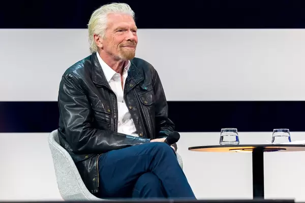 Unternehmer Richard Branson sitzt bequem und spricht auf der Digital X in Köln