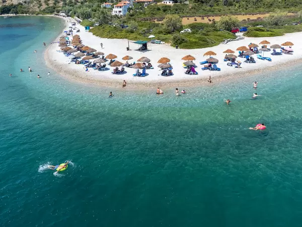 Urlauber genießen das klare Wasser und die Ruhe des Strandes Agios Dimitrios auf Alonnisos. Luftbild