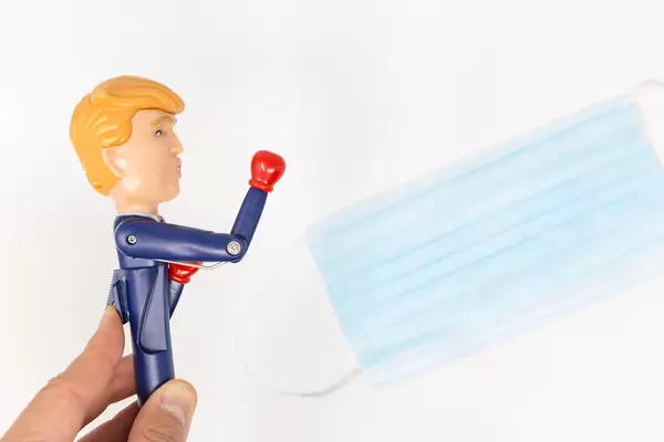 US-Covid-crisis - Donald Trump pen stretches his arm forward with a red boxing glove in front of face mask