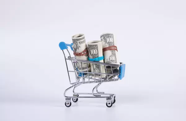 US dollar bills in rolls inside supermarket shopping cart