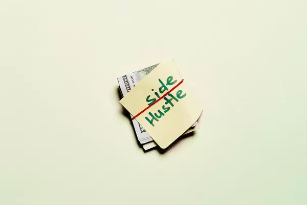 US dollars and sticky note with text SIDE HUSTLE