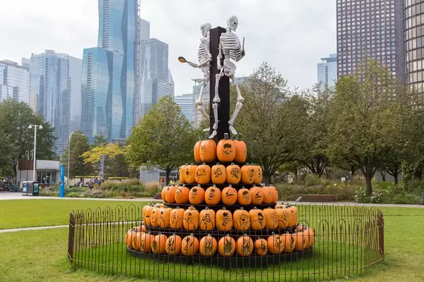USA feiern das Gruselfest Halloween, dekorierte Stadt, Skelette auf dem Scheiterhaufen aus geschnitzten Kürbissen