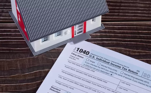 USA tax form 1040 and house on wooden table