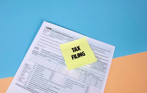 USA tax form 1040 for US individual tax return and sticky note with Tax Filling text