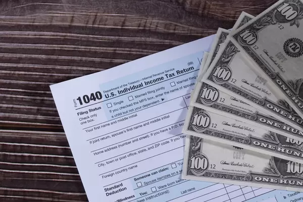 USA Tax Form 1040 with 100 dollars bills