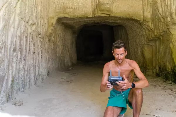Using a drone controller on a beach to take aerial photos while on holiday in Greece