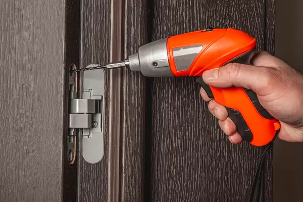 Using an electric screwdriver to install the door