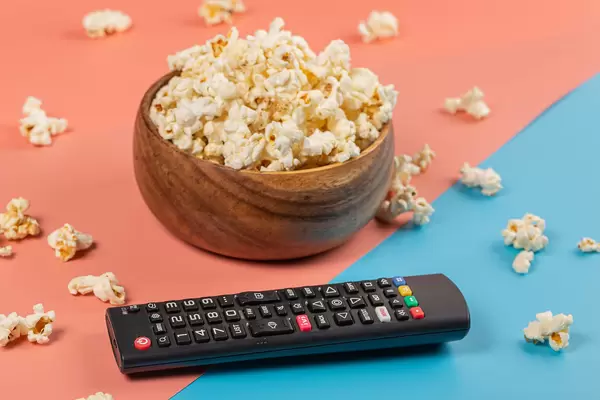 Vacation at home concept - popcorn and TV remote