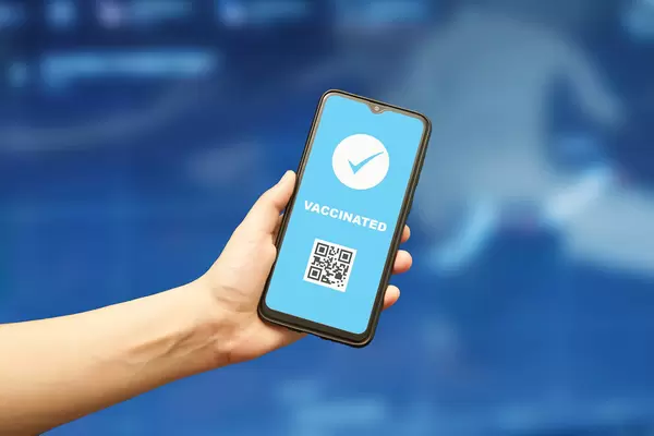 Vaccinated from COVID-19 person with digital health passport in smartphone