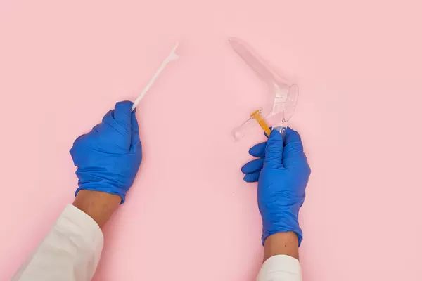 Vaginal speculum and spatula in hands of gynecologist doctor