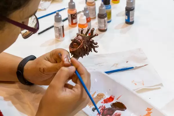 Vallejo Acrylfarben: Eine Frau bemalt eine Spielfigur Auf der Spiel in Essen