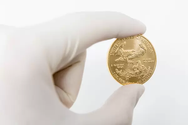 Value of the Coronavirus crisis in the US: hand wearing a one-way glove holds one ounce gold