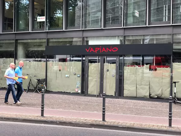 Vapiano in Cologne closed due to bankrupt: two men walk past a former restaurant of the chain
