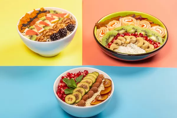 Variants of a healthy breakfast of oatmeal on the yellow, pink and blue backgrounds