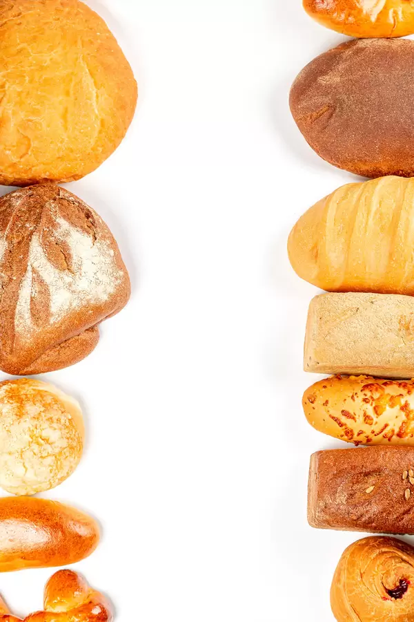 Variety of fresh yummy bread on white, top view with free space