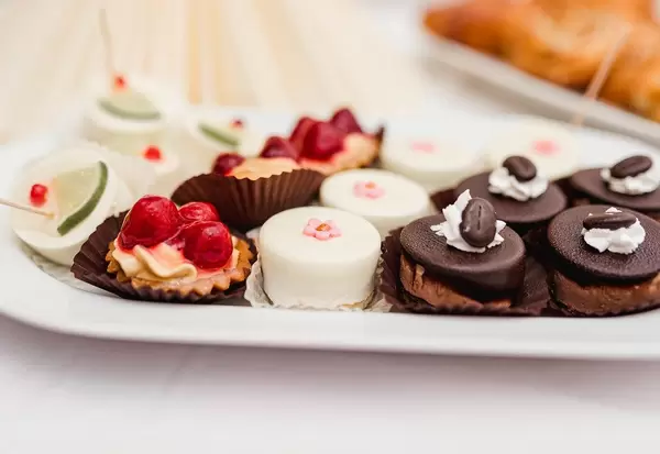 Variety Of Sweet Cakes With Coffee, Rasberries And Cream