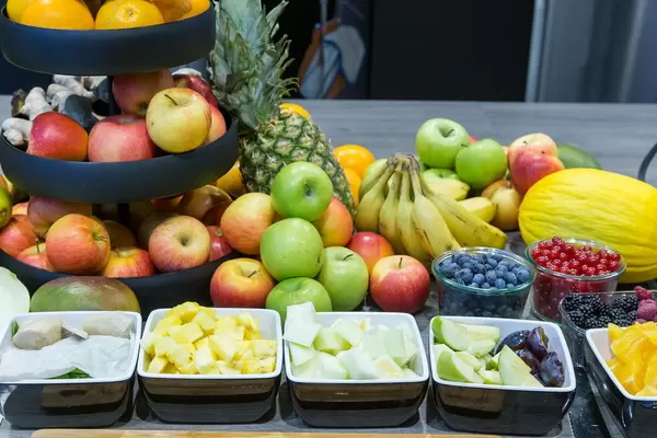 Various fresh berries and fruits, partly cut into pieces