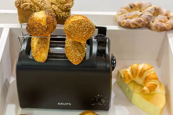 Various rolls and German pastries on a black Krups toaster oven