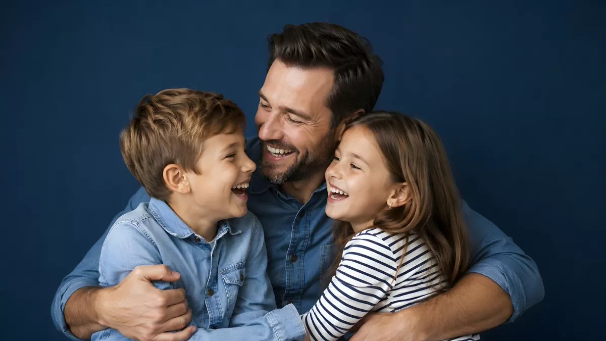 Vater lacht herzlich mit Sohn und Tochter