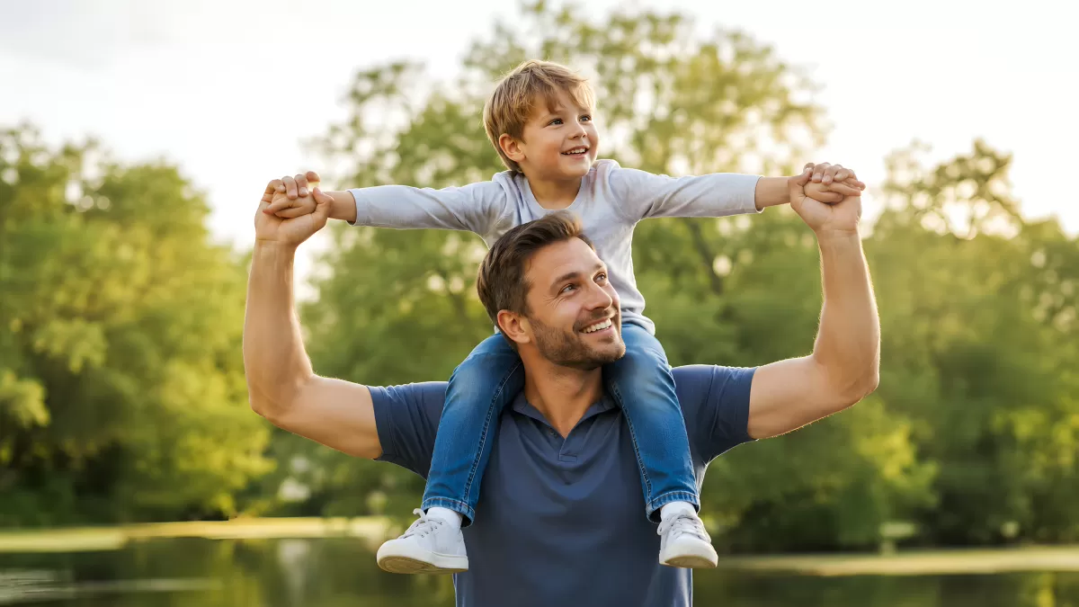 Vater trägt lachenden Sohn auf den Schultern im Park