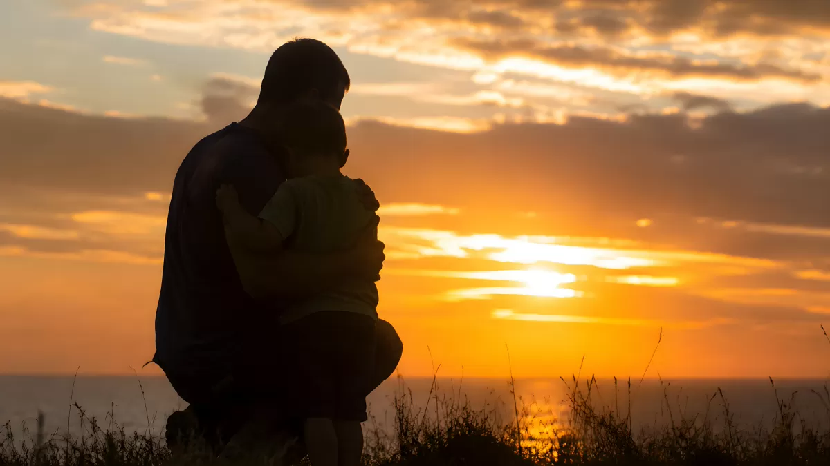 Vater und Kind beobachten gemeinsam den Sonnenuntergang