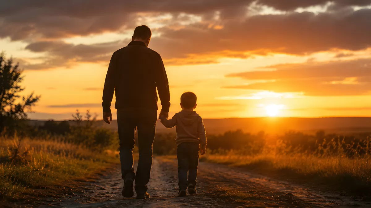 Vater und Sohn gehen Hand in Hand zum Sonnenuntergang