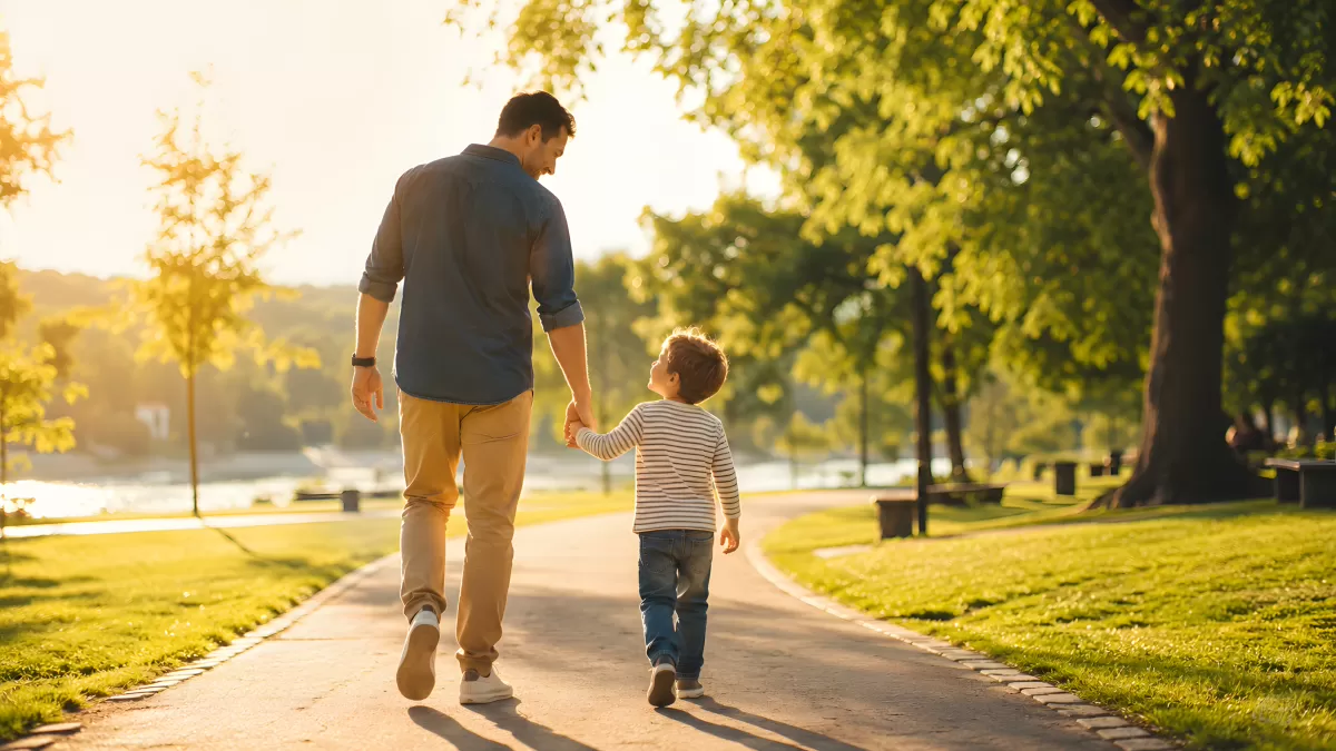 Vater und Sohn spazieren Hand in Hand im Park