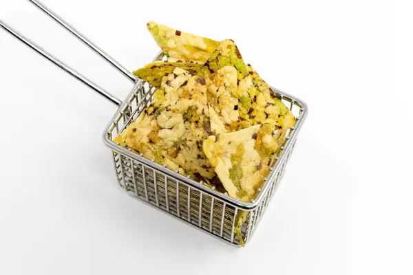 Vaya Bean Salt Snack von Zweifel, mit Erbsen, schwarzen Bohnen, Reismehl und Kichererbsen, als gesunder, veganer Snack, in einem kleinen Frittierkorb.