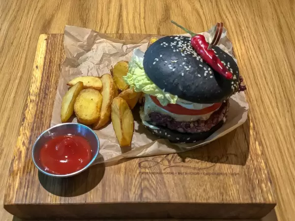 Veg Kuro Burger at Avocado Cafe: lentil and cereal patty, blackened bun made with use of charcoal, peanut sauce, tomatoes, pickles, lettuce leaves, chilli pepper