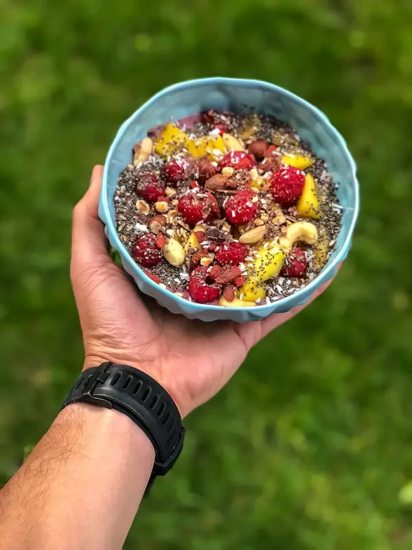 Vegan Acai Bowl with mango, nuts, raspberries, goji berries, chia and chocolate