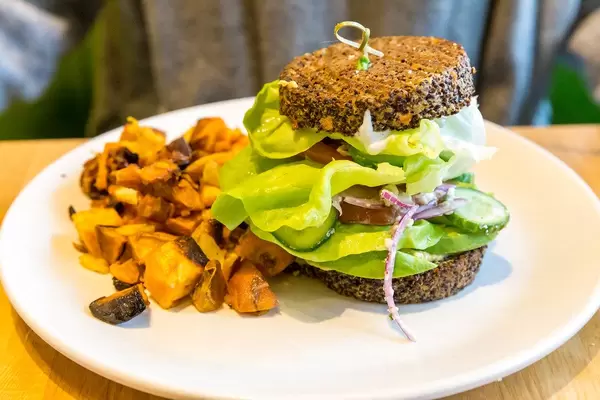 Vegan and gluten-free food in Chicago: Inside Out Quinoa Burger by True Food Kitchen with hummus, tzatziki, organic tomato, butter lettuce, cucumber, red onion, avocado, feta