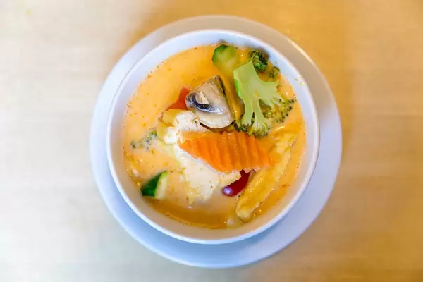 Vegan appetizer "Tom Yum", is a coconut milk based soup, spicy aromatic, with tofu, fresh carrots, broccoli and mushrooms