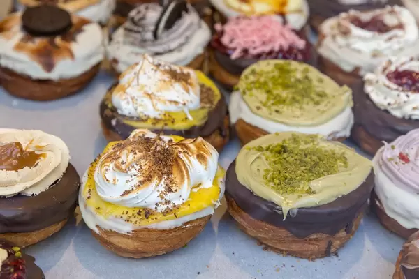 Vegan "Kronut" pastries with white and dark chocolate glaze, nut topping, caramel and cinnamon by chök in Barcelona, Spain