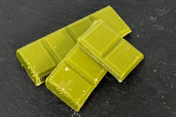 Vegane Mandel-Schokolade mit Matcha auf schwarzem Hintergrund