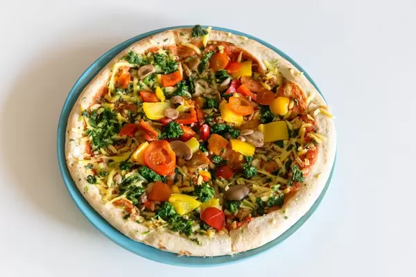 Vegane Pizza Verdura mit Spinat, Champignons, Paprika, Cherrytomaten und Kokosöl