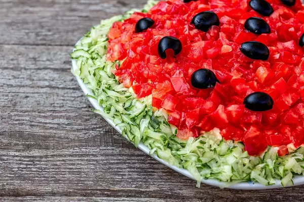 Veganer Salat mit Tomaten, Gurken und Oliven in Nahaufnahme