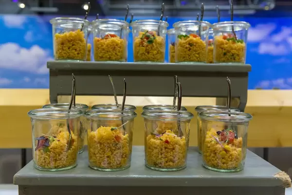 Veganes Couscous Salat mit Tomaten, Mais, roten Zwiebeln und Keimen in kleinen Gläschen auf dem BarCamp in Bonn